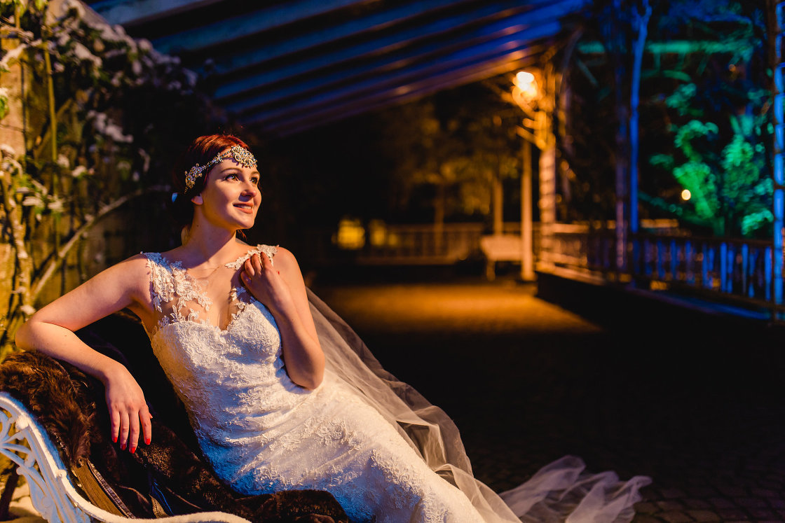 Braut im Brautkleid und Schleier mit Juwelenschmuck bei Nacht im Europa Park
